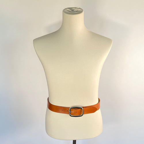 A mannequin with a brown leather belt and round stainless steel buckle.