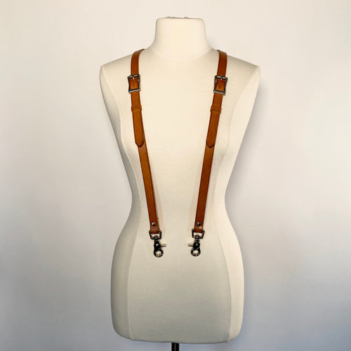 A mannequin with brown leather suspenders and stainless steel hardware